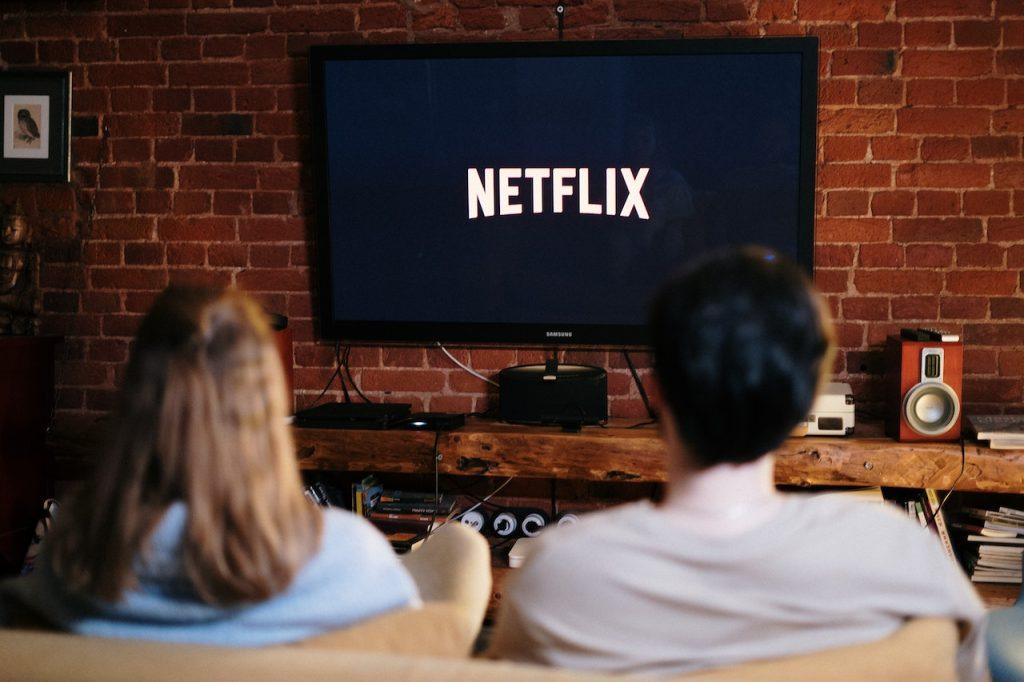 Top 5 Survival Movies on Netflix - The Must-Watch Films, a man and a woman watching Netflix on the TV