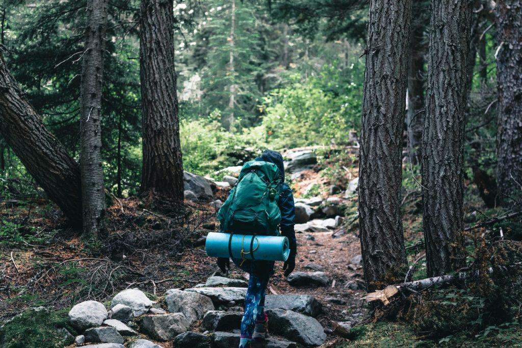 Wilderness Adventure Gear Must-Haves [Essential Guide], a woman with hiking gear in the great outdoors
